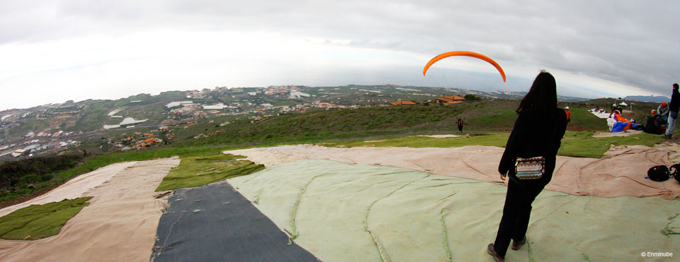 Person, die einen Gleitschirm über die Landschaft von Los Realejos auf Teneriffa beobachtet.