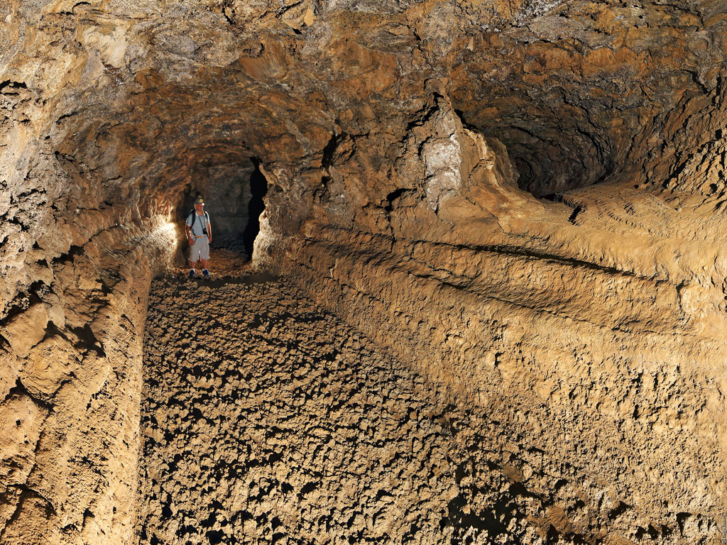 Person, die eine Vulkanhöhle auf Teneriffa erkundet.