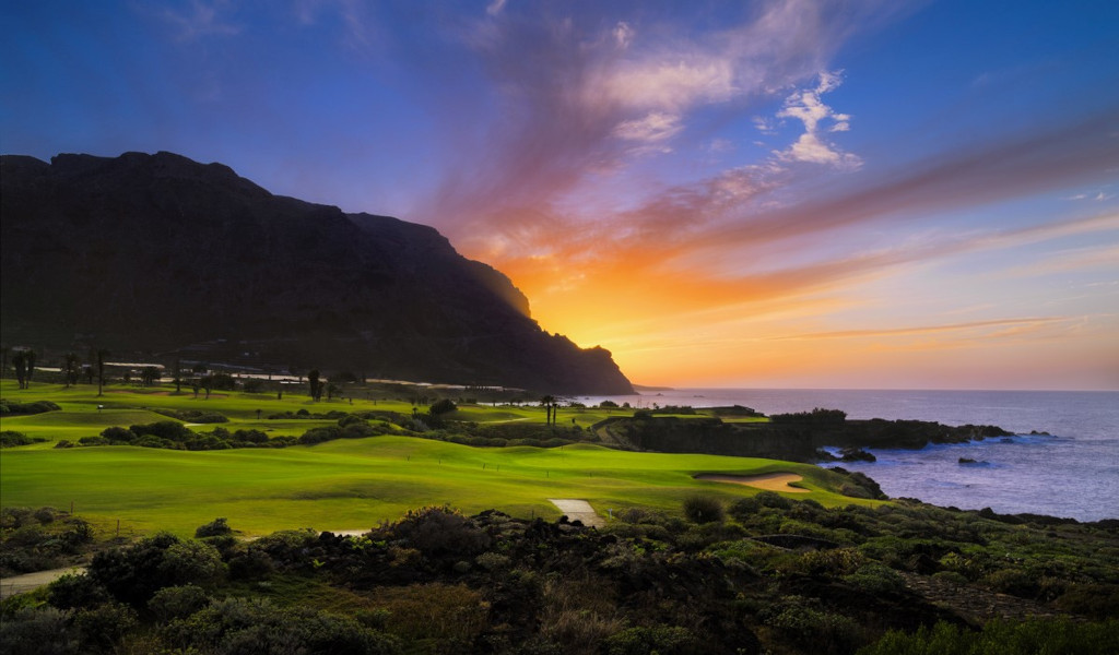 Sonnenuntergang über einem Golfplatz auf Teneriffa am Meer.