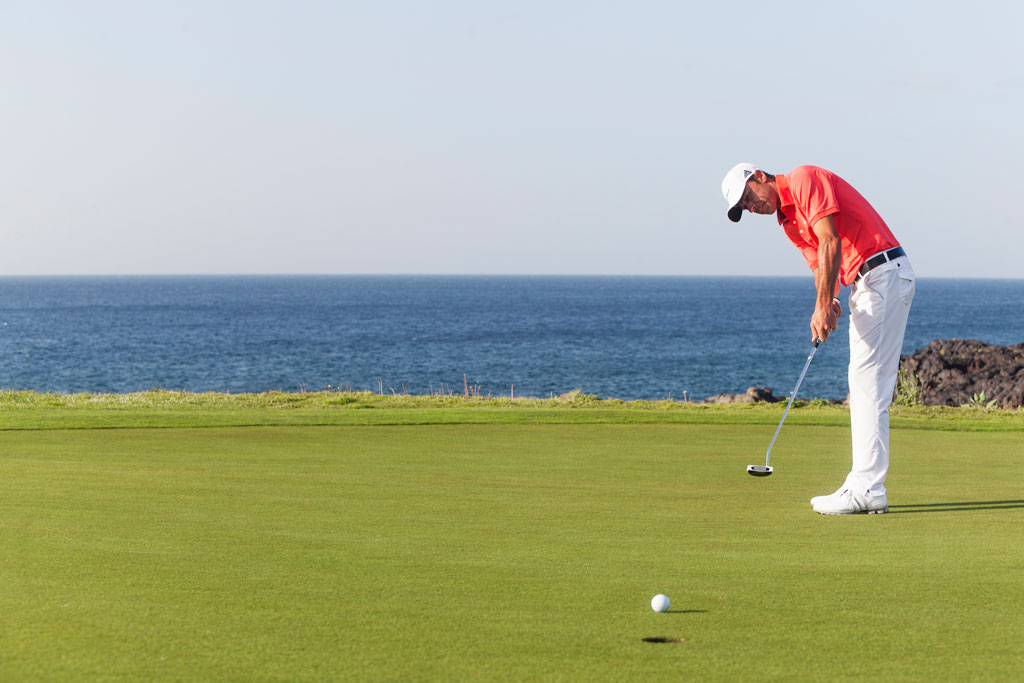 Person, die Golf am Meer auf Teneriffa spielt.