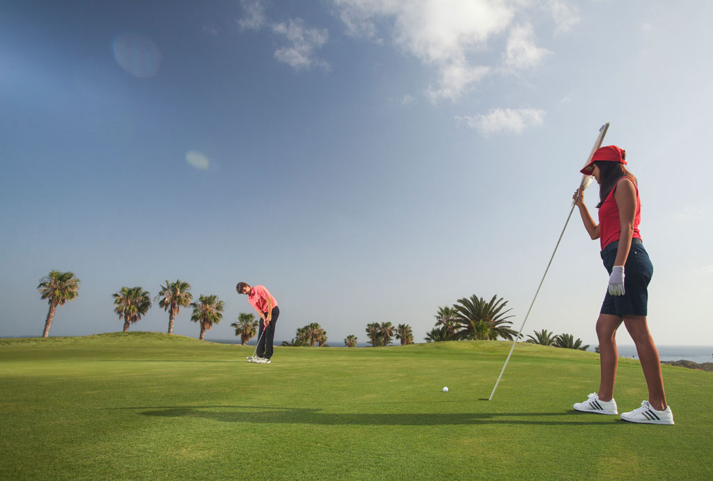 Golfer auf dem von Palmen umgebenen Platz auf Teneriffa.