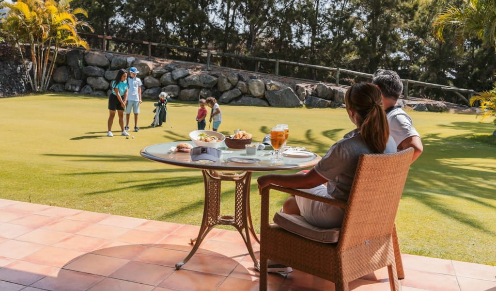 Leute, die Golf spielen und in einem Club auf Teneriffa essen.