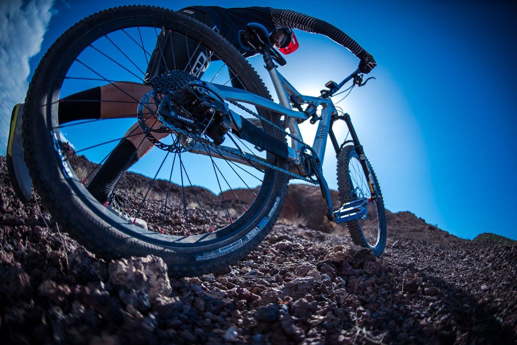 Mountainbike-Radfahrer über felsiges Gelände auf Teneriffa bei blauem Himmel.