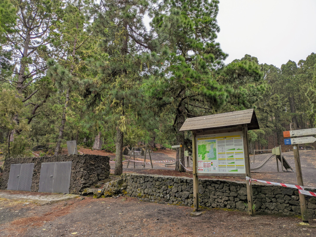 Erholungsgebiet mit Karte und Schildern in La Esperanza, Teneriffa, umgeben von Kiefern und Wegen.