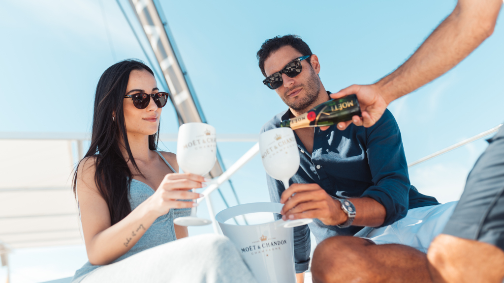 Menschen, die mit Moët & Chandon Champagner auf einer Yacht auf Teneriffa anstoßen.