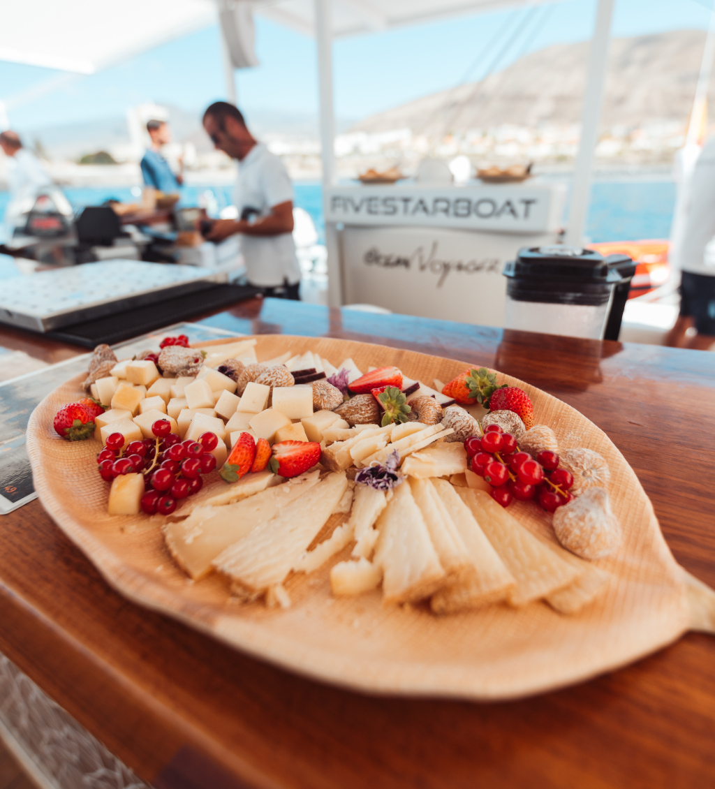 Käse- und Obsttabletts mit dem Boot auf Teneriffa, Meeresboden und Bergen.