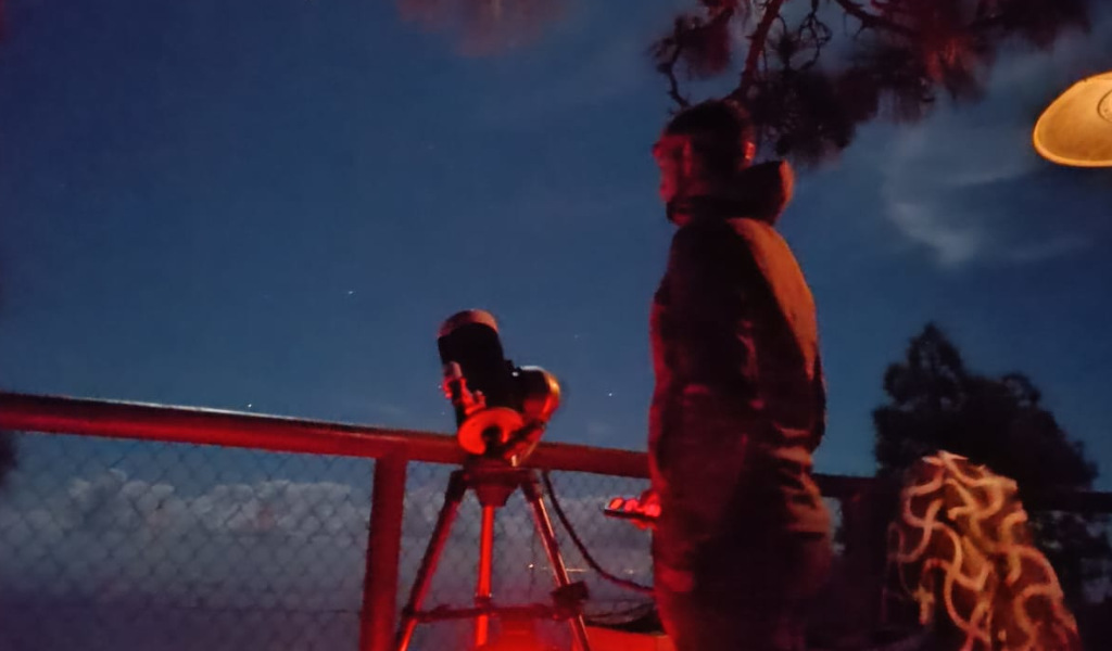 Person, die den Nachthimmel mit einem Teleskop beobachtet, möglicherweise auf Teneriffa.