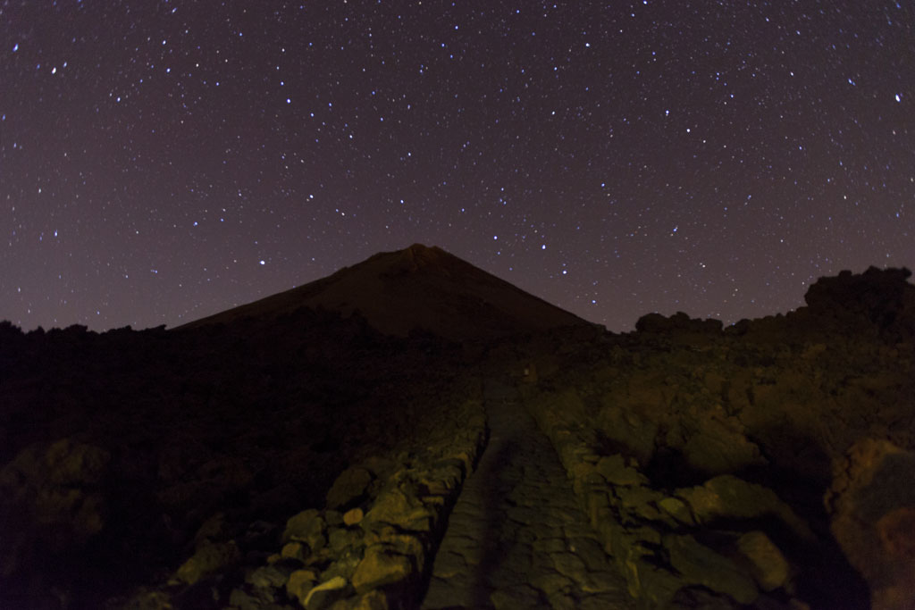 Sternenhimmel über dem Teide auf Teneriffa, mit felsigem Pfad im Vordergrund.