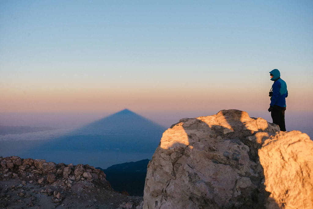 Person, die den Schatten des Pico del Teide bei Tagesanbruch auf Teneriffa beobachtet.