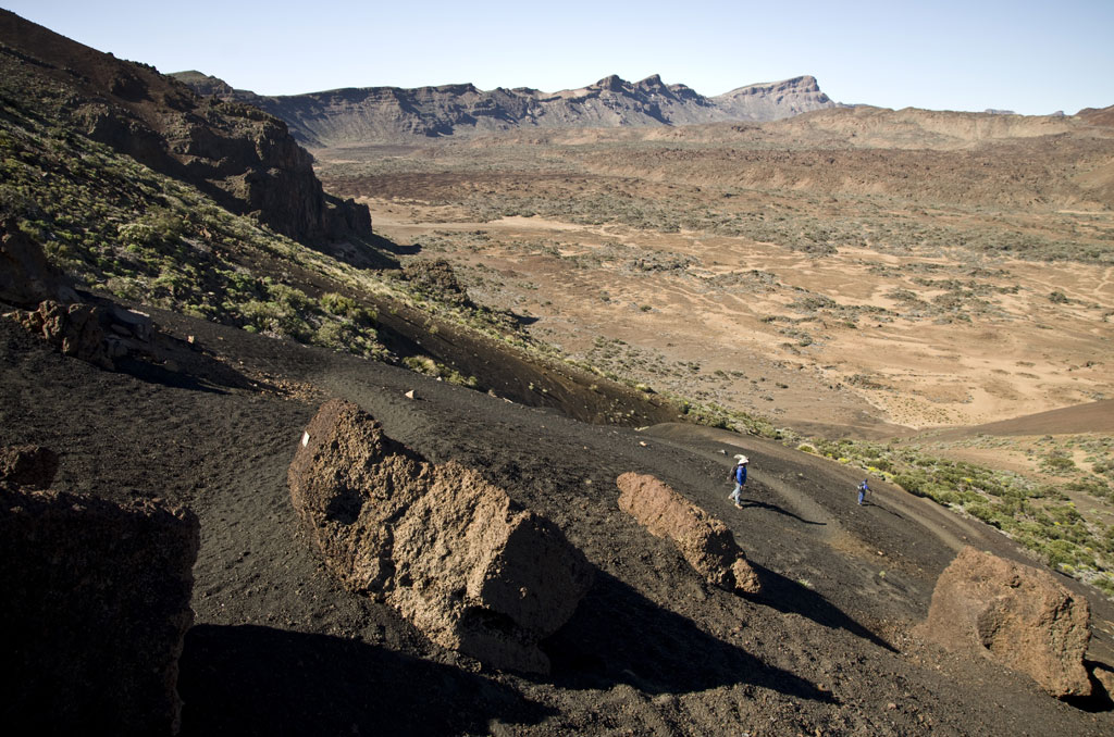 Vulkanische Landschaft mit zwei Personen, die im Teide-Nationalpark auf Teneriffa spazieren gehen.