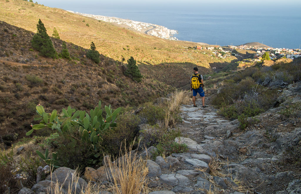 Person, die auf dem Weg zum Meer in der bergigen Landschaft von Teneriffa wandert.