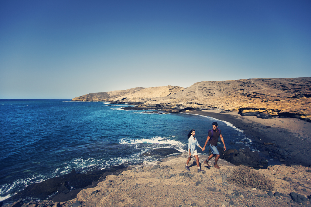 Ein Paar spaziert am Meer in einer Küstenlandschaft von Teneriffa.