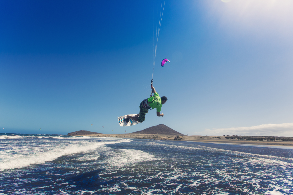 Person kitesurft am Strand von El Médano auf Teneriffa bei klarem Himmel.