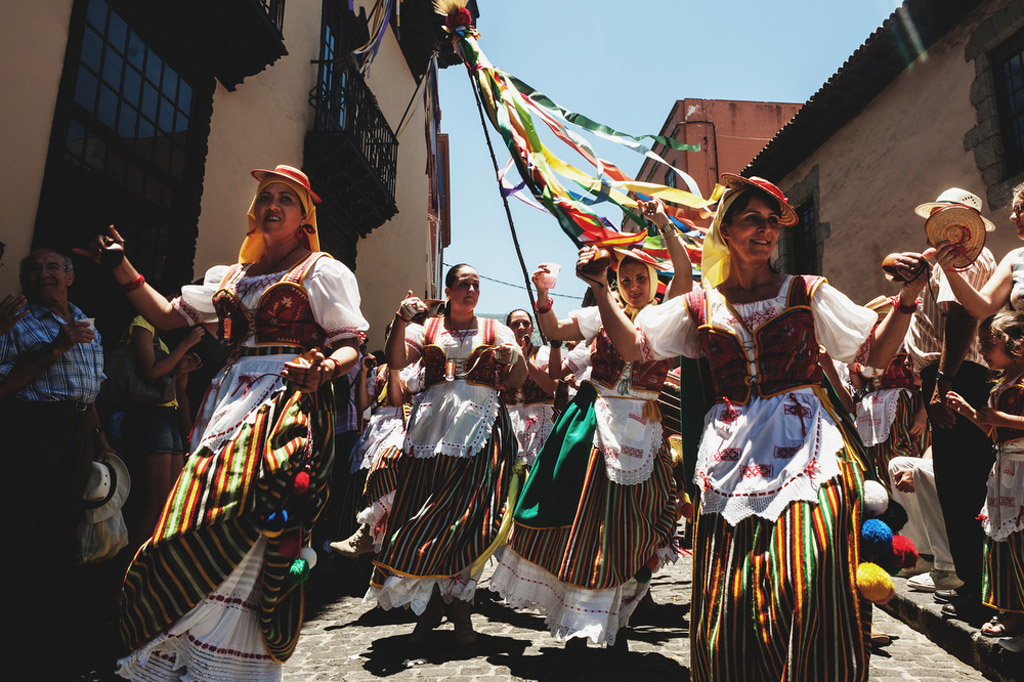 Menschen in traditionellen Kleidern tanzen auf einer Straße auf Teneriffa.