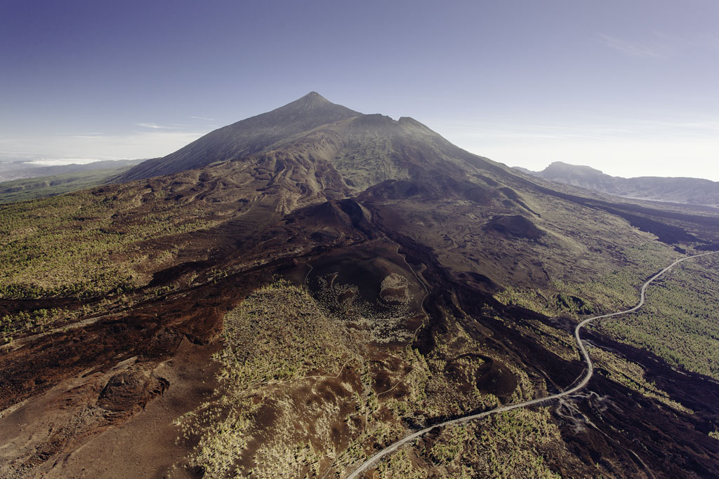 Luftaufnahme des Berges Teide auf Teneriffa mit vulkanischer Landschaft und einer Straße.