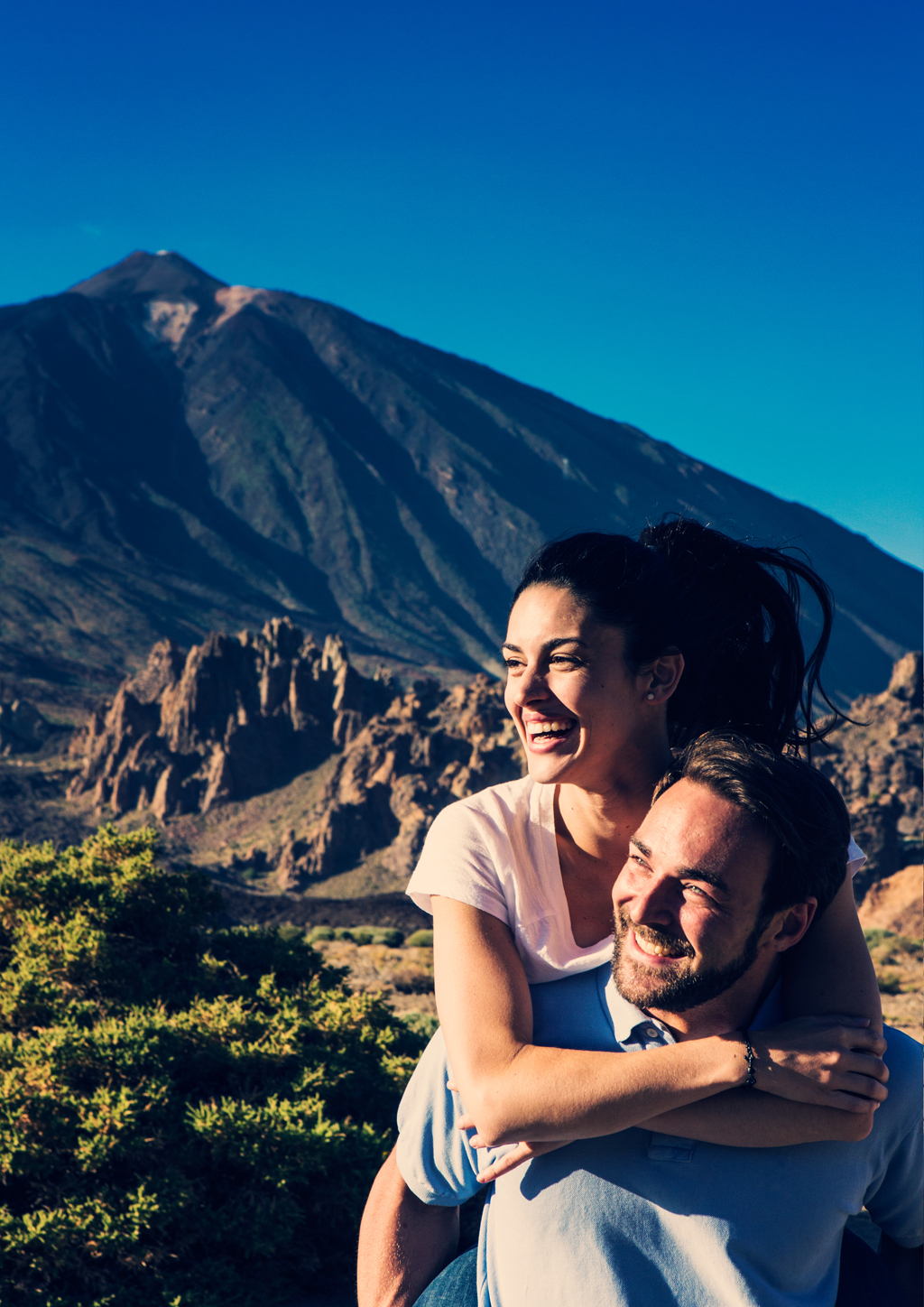 Ein Paar, das lächelt, mit dem Teide-Berg auf Teneriffa im Hintergrund.