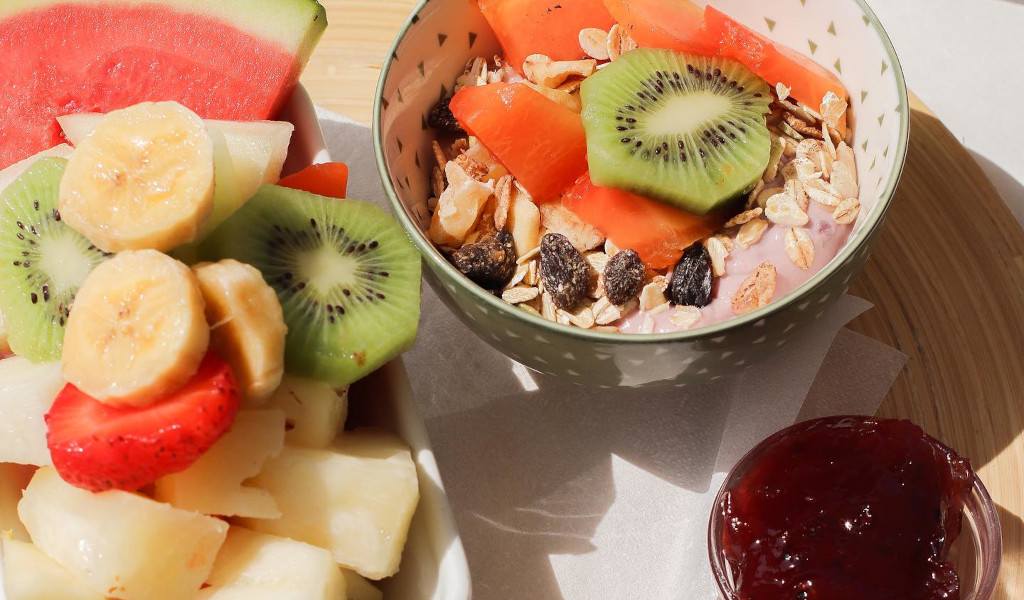 Eine Schüssel Joghurt mit Kiwi, Papaya, Müsli und frischem Obst auf Teneriffa.