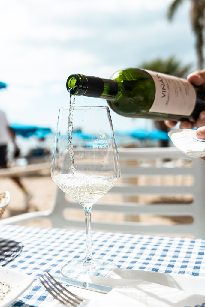 Weißwein wird in einem Glas auf einem Tisch mit kariertem Tischtuch auf Teneriffa serviert.