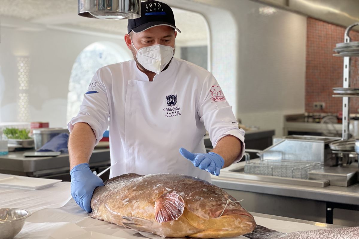 Koch auf Teneriffa bereitet frischen Fisch in der Küche zu.