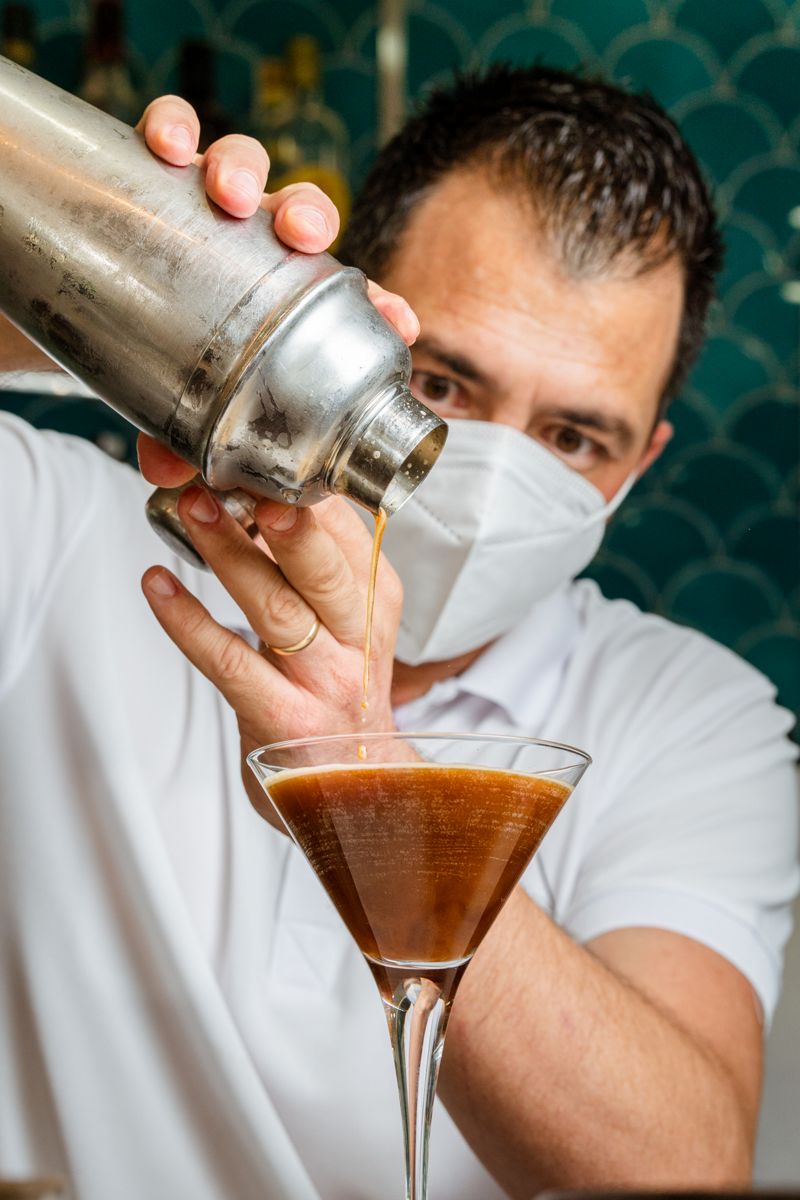 Mixologe serviert ein Getränk in Martini-Glas auf Teneriffa.
