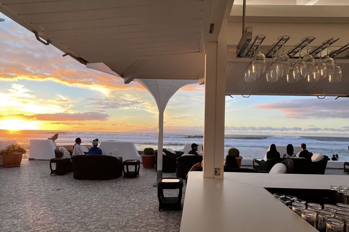 Terrasse auf Teneriffa mit Menschen, die den Sonnenuntergang über dem Meer beobachten.