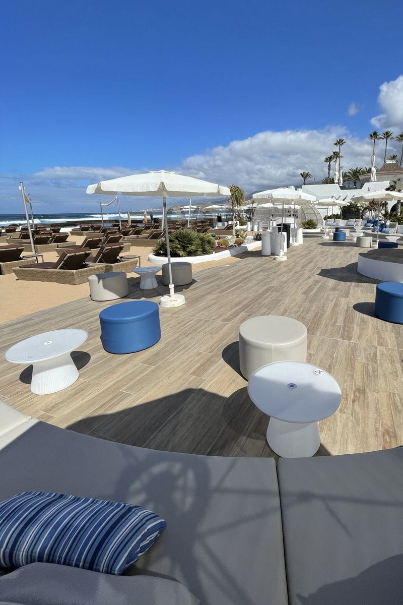 Strandterrasse mit Tischen und Stühlen in einem Resort auf Teneriffa.