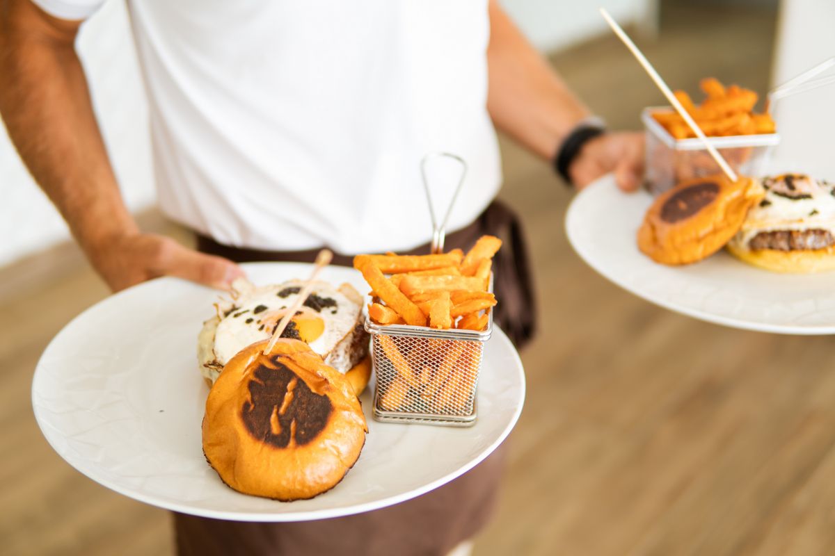 Teller mit Burgern und Pommes werden auf Teneriffa serviert.