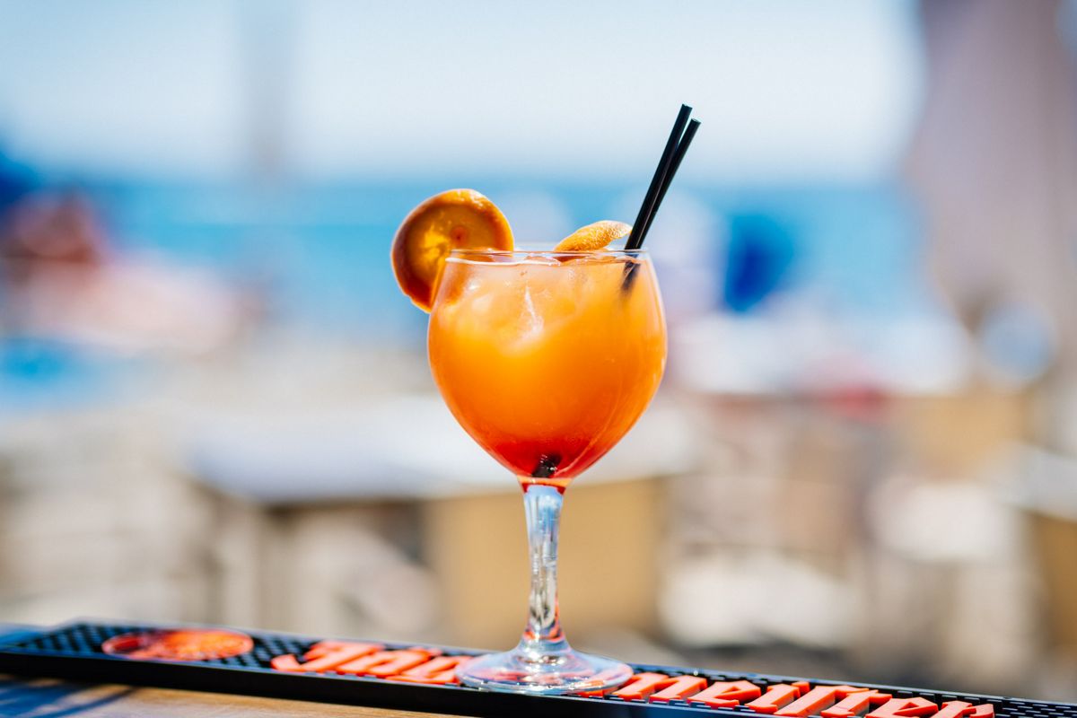 Cocktail mit Orangenscheibe und zwei schwarzen Strohhalmen in einer Bar auf Teneriffa.
