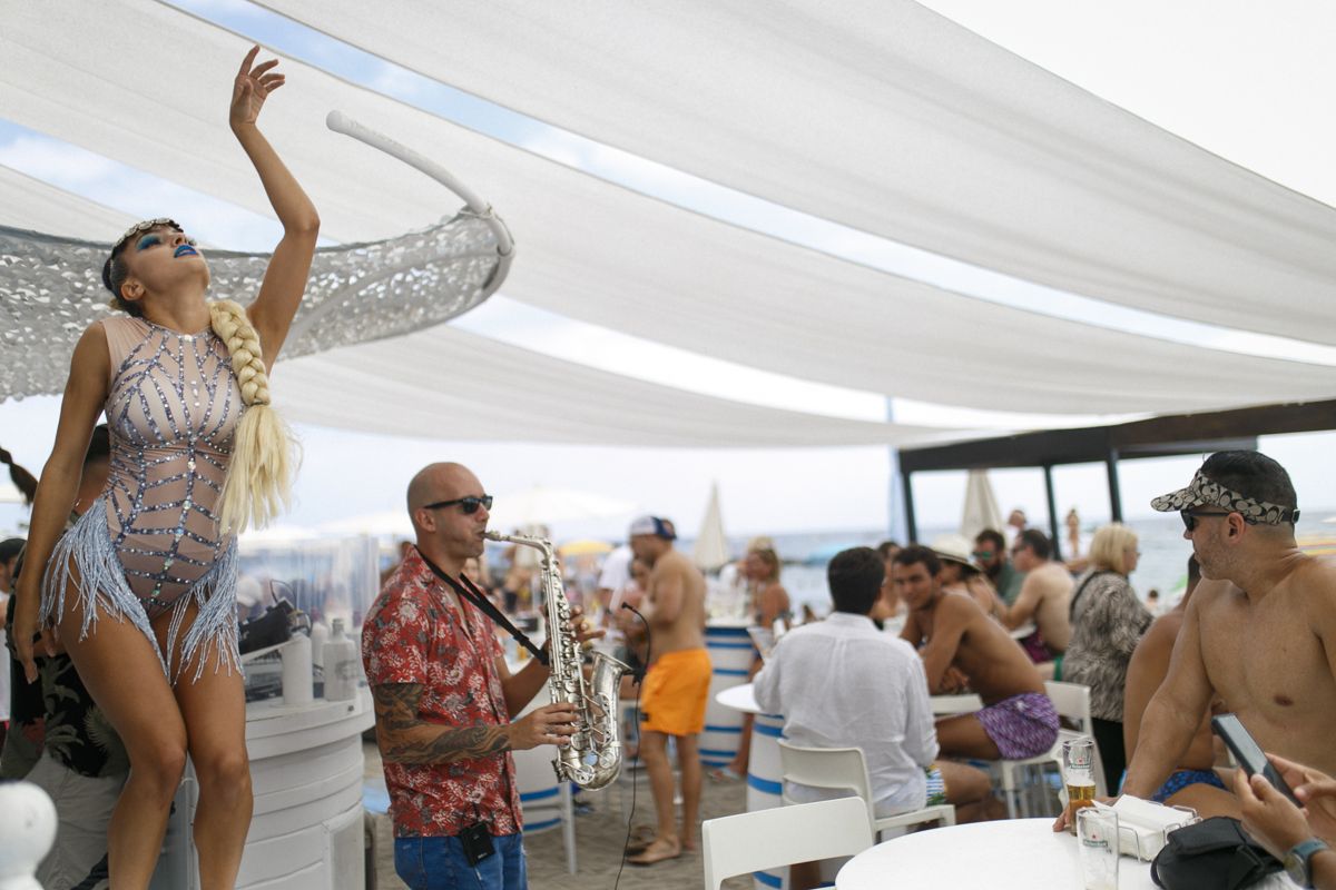Tänzer und Musiker, der Saxophon bei einer Outdoor-Veranstaltung am Strand von Teneriffa spielt.