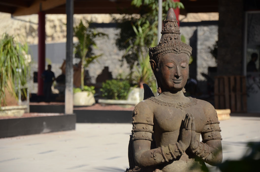 Buddha-Statue mit gefalteten Händen in einem Garten im Siam-Park, Teneriffa.