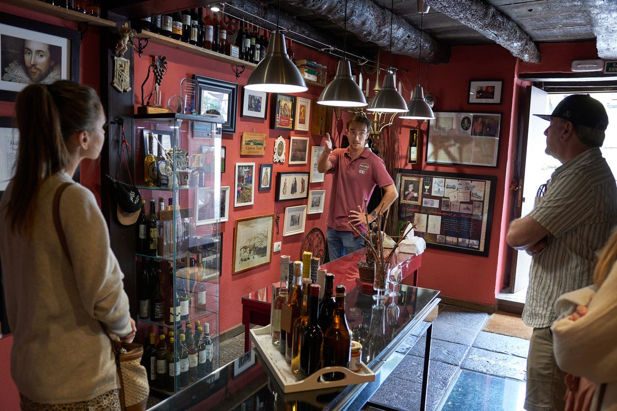 Ein Mann, der Touristen von Weinen erklärt, umgeben von Flaschen und Dekorationen auf Teneriffa.