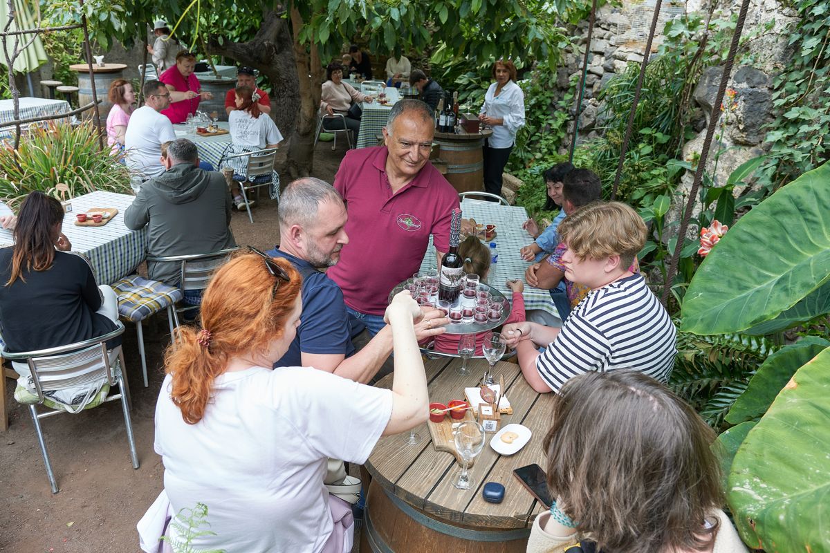 Menschen, die auf der Terrasse eines Restaurants auf Teneriffa Getränke teilen.
