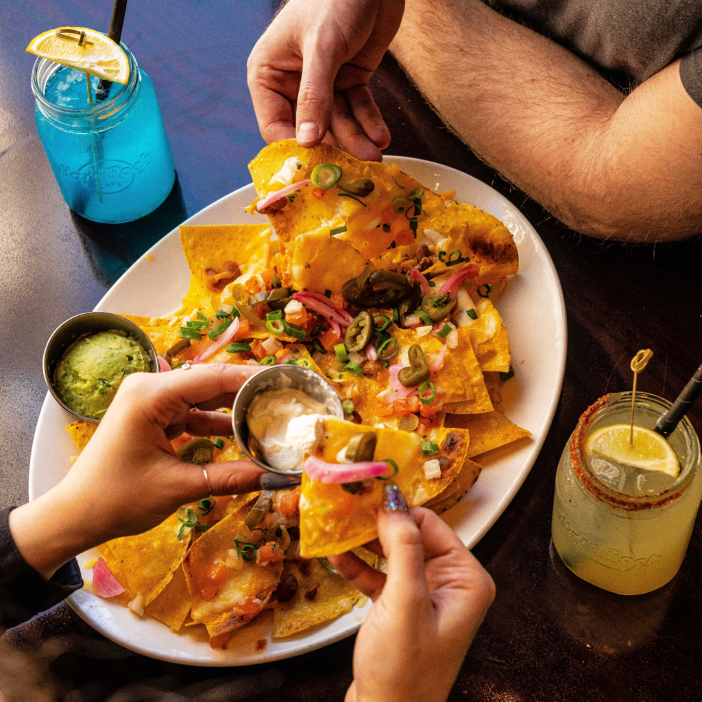 Nachos mit Guacamole und Sauerrahm in einem Restaurant auf Teneriffa, begleitet von Getränken.