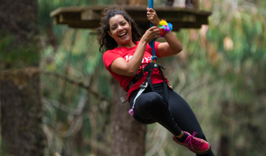 Person, die eine Zipline-Fahrt in einem Wald auf Teneriffa genießt.