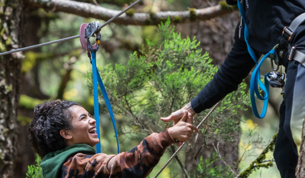 Person, die beim Ziplining in einem Wald auf Teneriffa lacht.