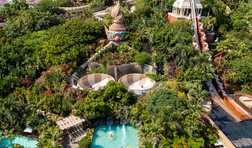 Luftaufnahme des Wasserparks Siam Park auf Teneriffa mit Rutschen und üppiger Vegetation.