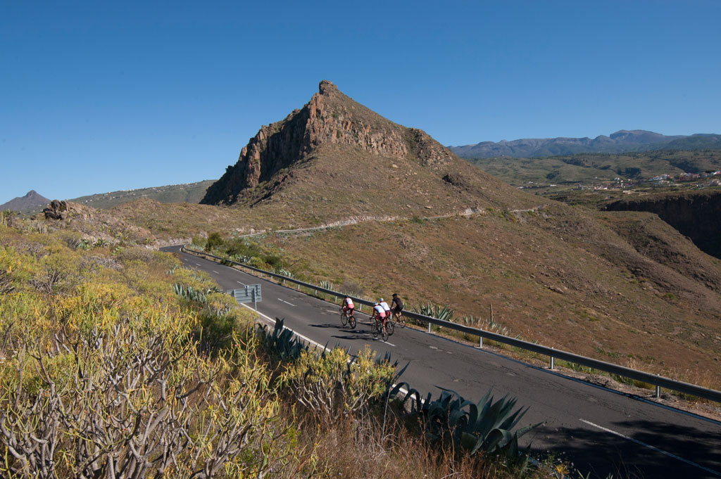 Radfahrer auf einer Bergstraße auf Teneriffa, umgeben von trockenen Landschaften.