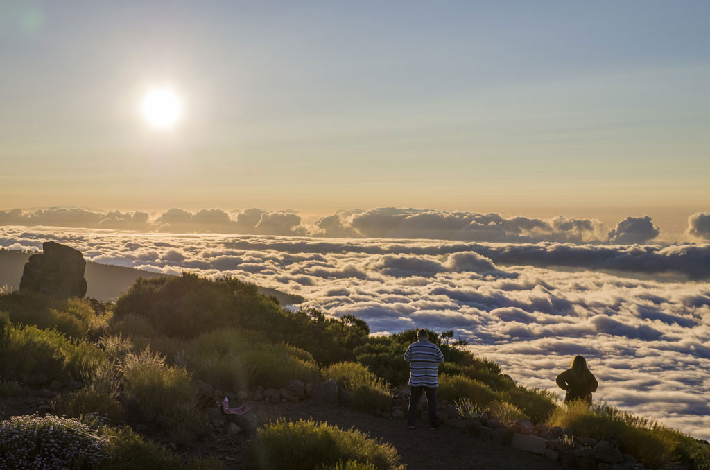 Menschen, die einen Sonnenuntergang über den Wolken im Teide-Nationalpark auf Teneriffa beobachten.