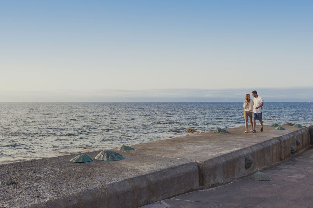 Ein Paar spaziert am Pier am Meer auf Teneriffa.