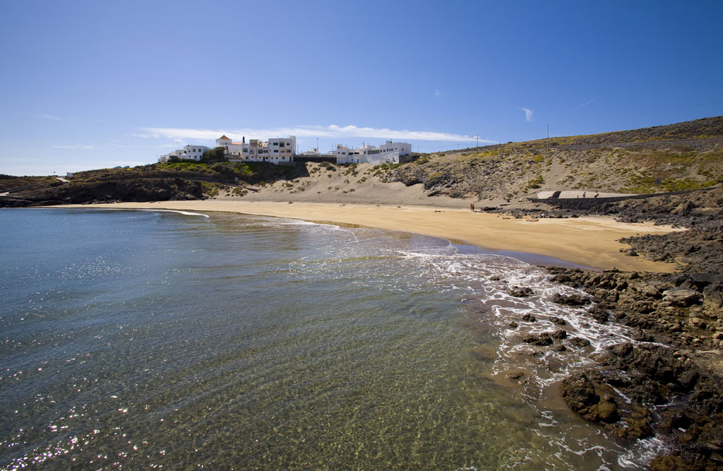 Strand mit goldenem Sand und Gebäuden im Hintergrund an der Küste von Teneriffa.