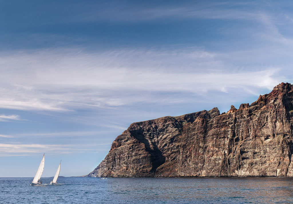 Segelboote, die vor den Klippen von Los Gigantes, Teneriffa, segeln.