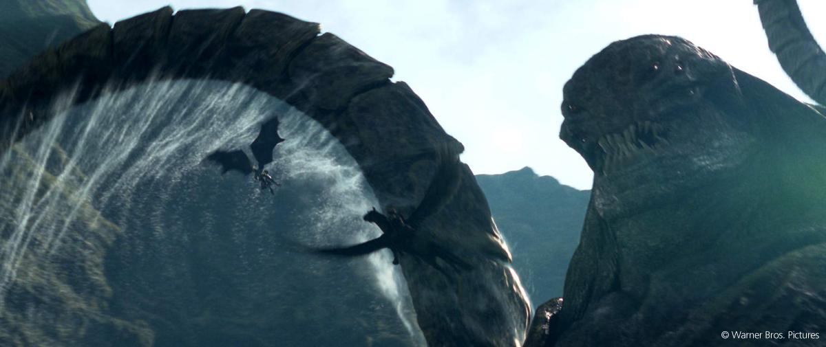 Riesige Kreatur in Form eines Seeungeheuers vor Drachen, die zwischen Bergen und einer großen Welle hindurchfliegen.