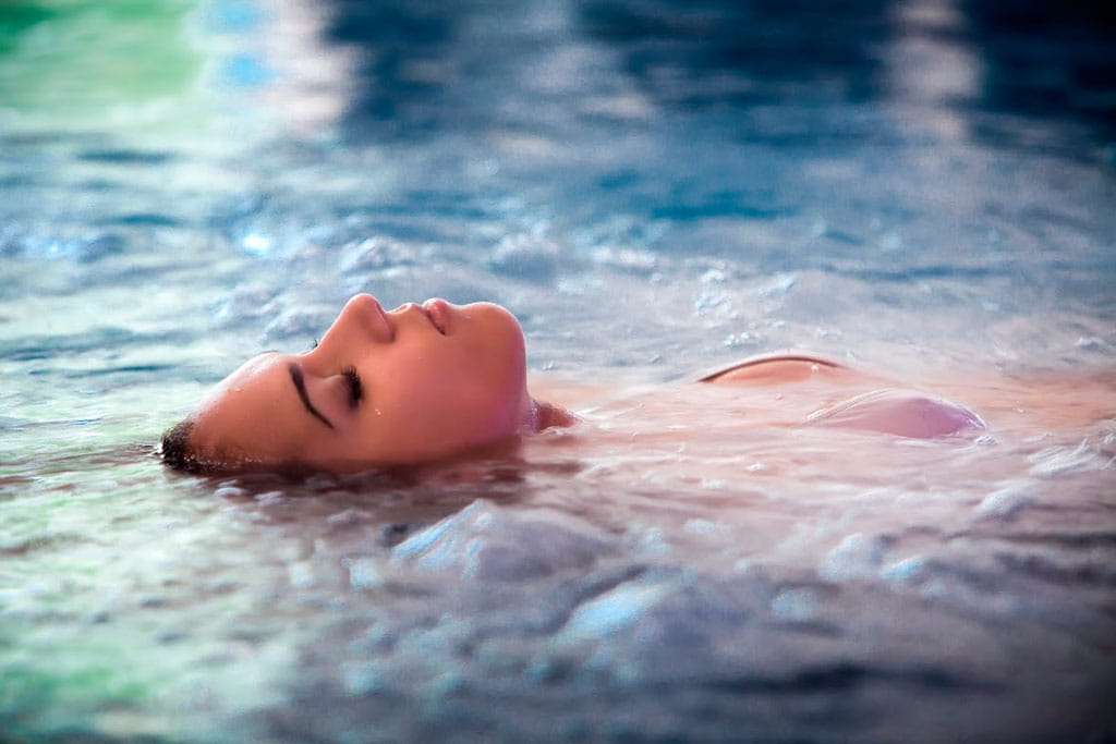 Person, die auf dem Rücken im Wasser in einem Spa auf Teneriffa treibt.