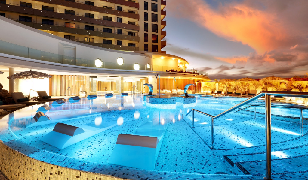 Schwimmbad beleuchtet bei Einbruch der Dämmerung in einem Hotel auf Teneriffa.