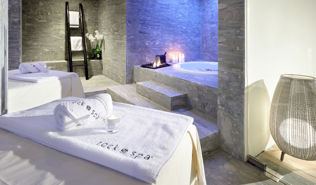 Spa mit Massagetisch, Handtüchern und beleuchtetem Jacuzzi auf Teneriffa.
