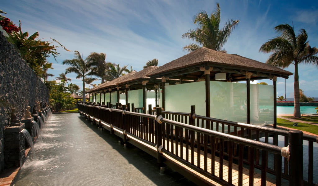 Holzweg mit Palmen und Mauern im Hotel Villa Cortés Tenerife.