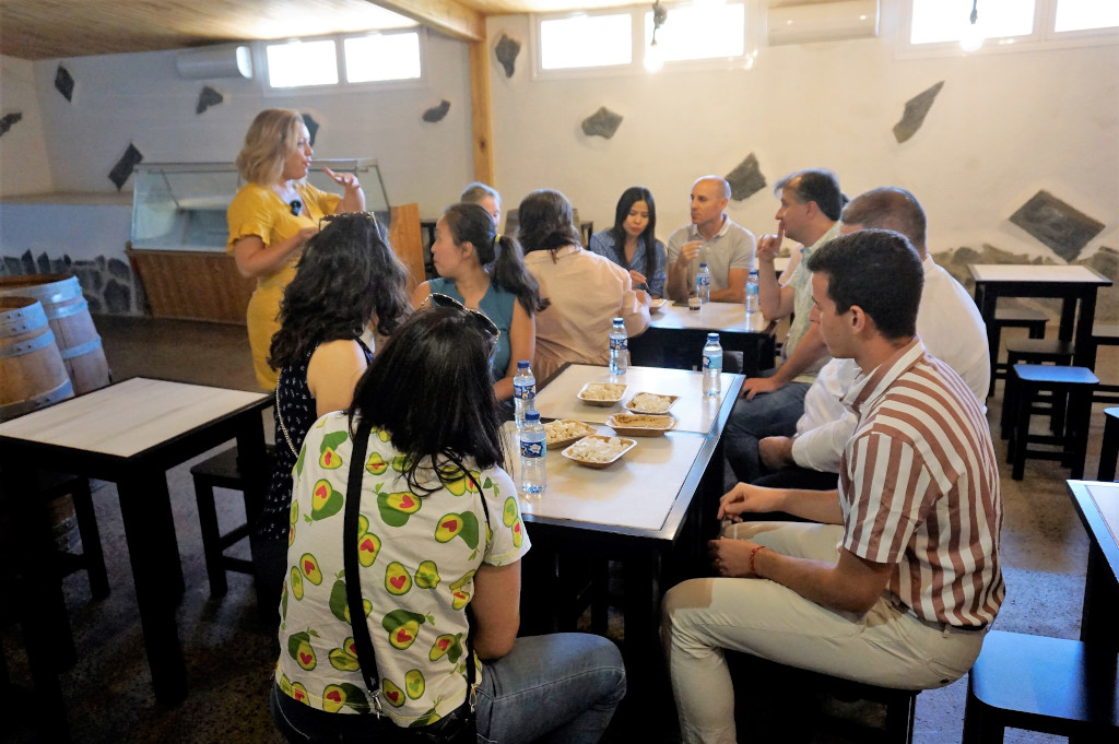 Eine Gruppe von Menschen versammelte sich in einem Weingut auf Teneriffa und teilte das Essen an den Tischen.