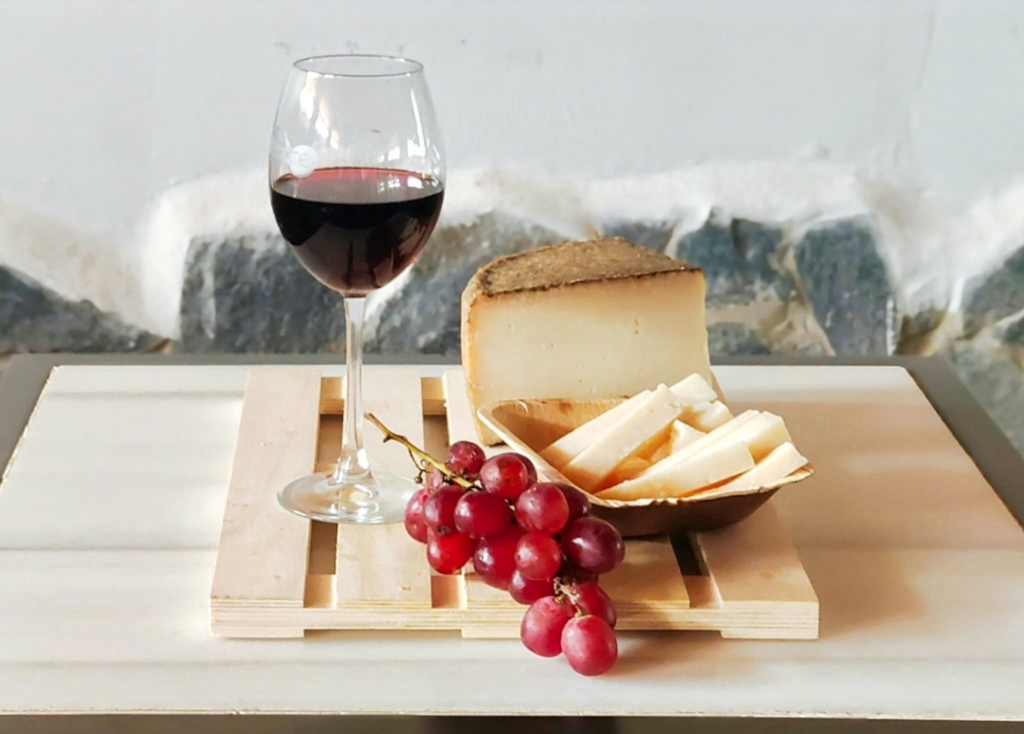 Glas Rotwein, Käse und rote Trauben auf einem Brett auf Teneriffa.