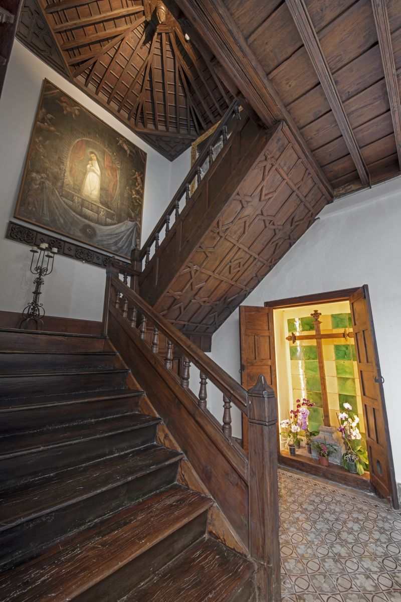 Holztreppe mit religiösem Gemälde und Buntglasfenster in einem Haus auf Teneriffa.