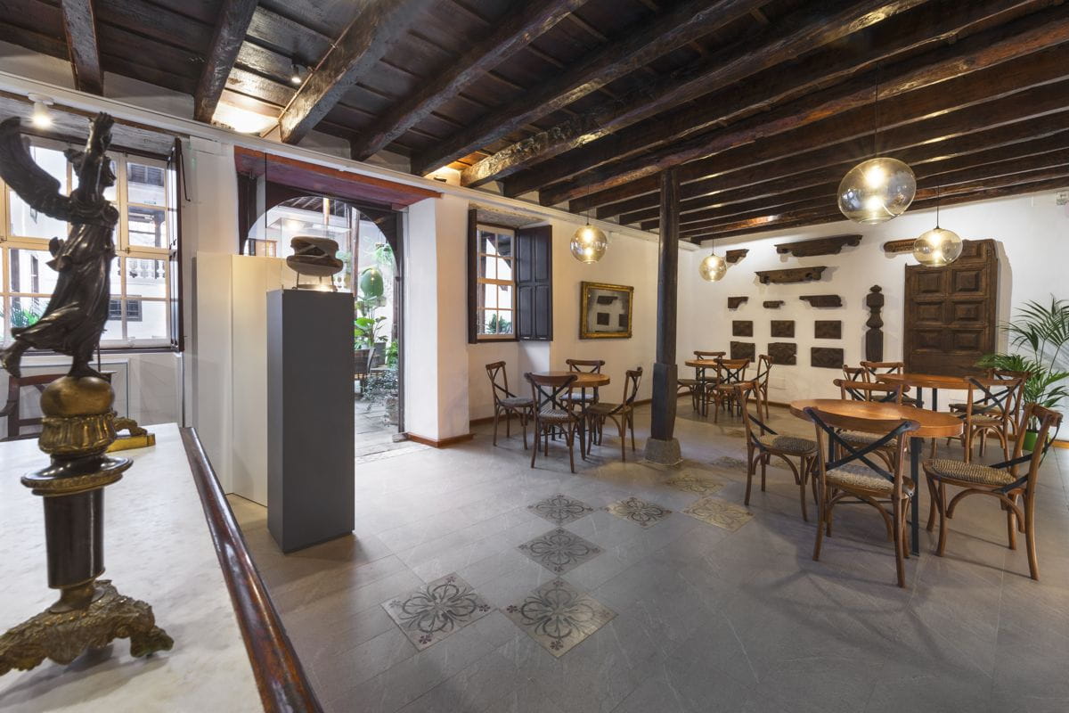 Innenraum eines historischen Cafés auf Teneriffa mit Holztischen und klassischem Dekor.